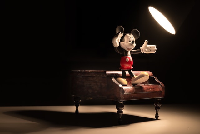 Mickey mouse figurine on a piano.