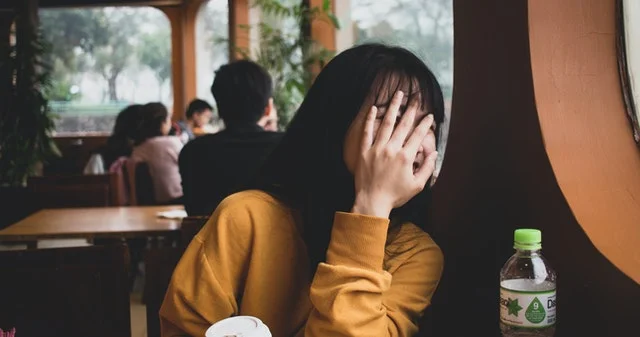 Girl covering her face.