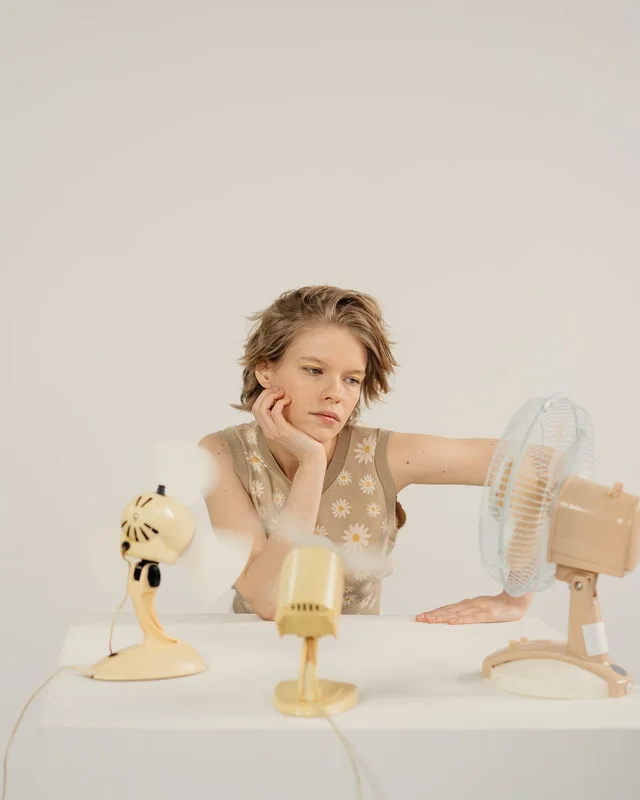 Student in front of table fans.