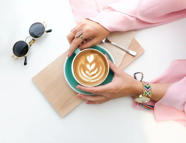 Hands holding a cup of coffee.