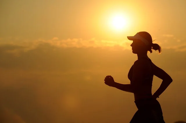 Student jogging in sunset.