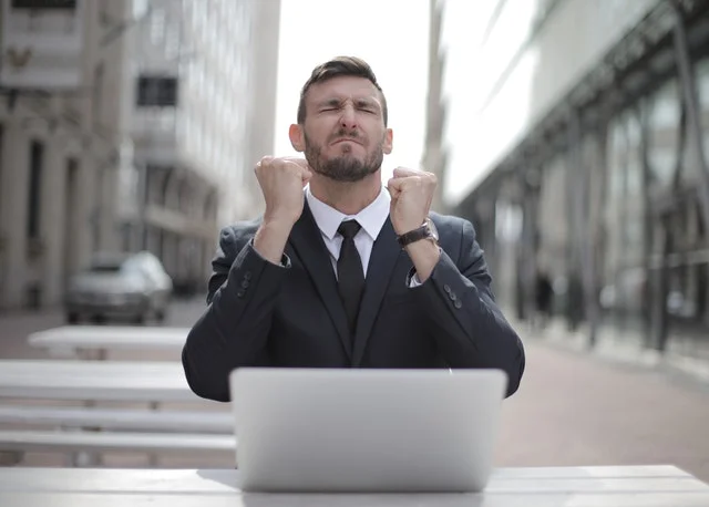 Happy businessman sitting in front of the laptop.