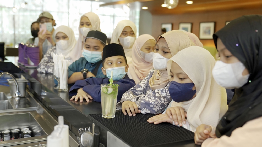 Children observe the making of a 'Raya Nojito' mocktail.
