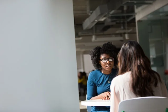 University student talking to lecturer about assignment deadline pressure.