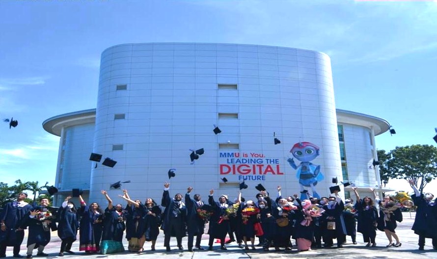 Graduates in front of MMU campus.